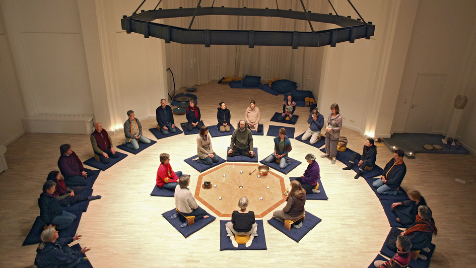 Menschen sitzen im Kreis in der 'Kirche der Stille' in Hamburg