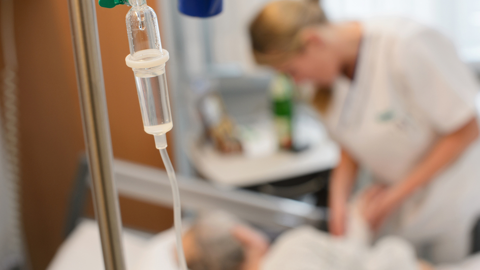 Krankenschwester am Bett eines schwerstkranken Patienten auf einer Palliativstation in einem deutschen Krankenhaus