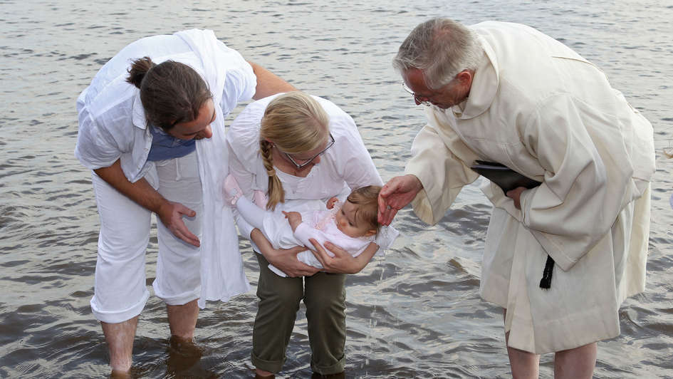 Kind wird in der Elbe getauft