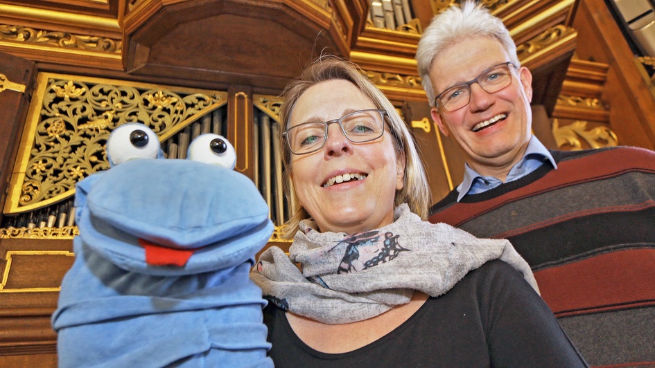 Anne-Katrin und Manuel Gera mit Orgelwurm Willibald vor der historischen Bielfeldt-Orgel in der St.-Wilhadi-Kirche