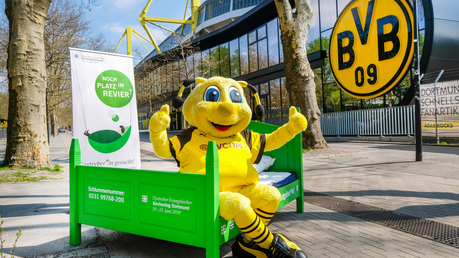 BvB-Maskottchen Emma wirbt vor dem Stadion für die Bettenkampagne 'Noch Platz im Revier?' des Kirchentages BvB-Maskottchen Emma wirbt vor dem Stadion für die Bettenkampagne 'Noch Platz im Revier?' des Kirchentages