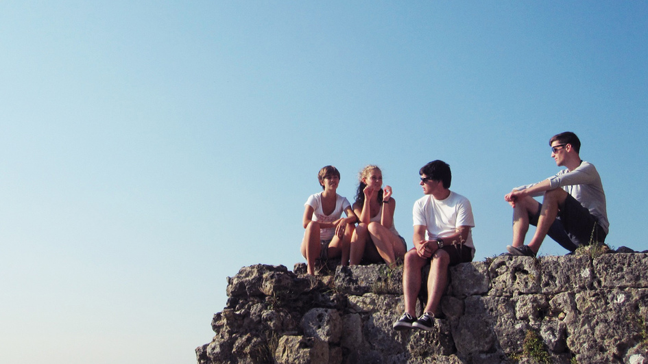 Junge Menschen sitzen auf einem Felsen Junge Menschen sitzen auf einem Felsen