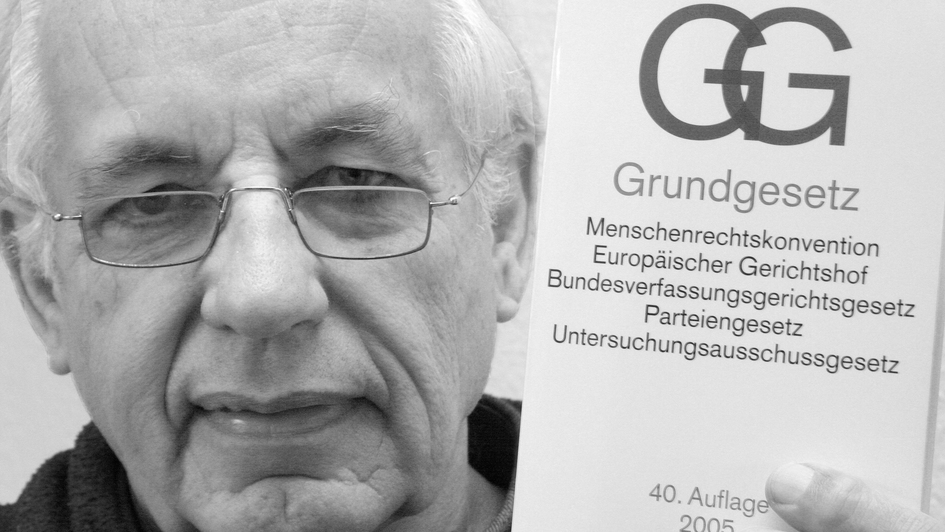 Ulrich Finckh hält das Grundgesetz der Bundesrepublik Deutschland