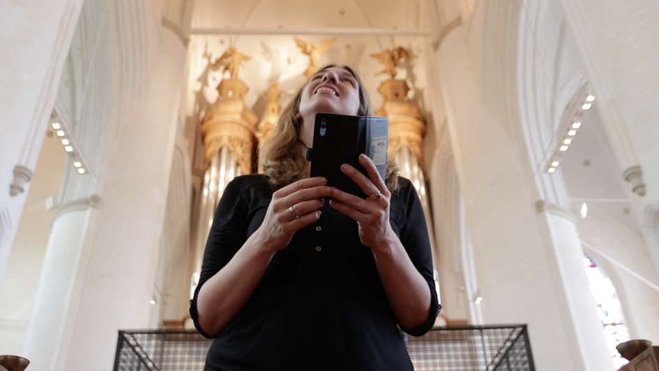 Religionspädagogin Friederike Wenisch mit Smartphone in der Hand in der St. Katharinen-Kirche in Hamburg