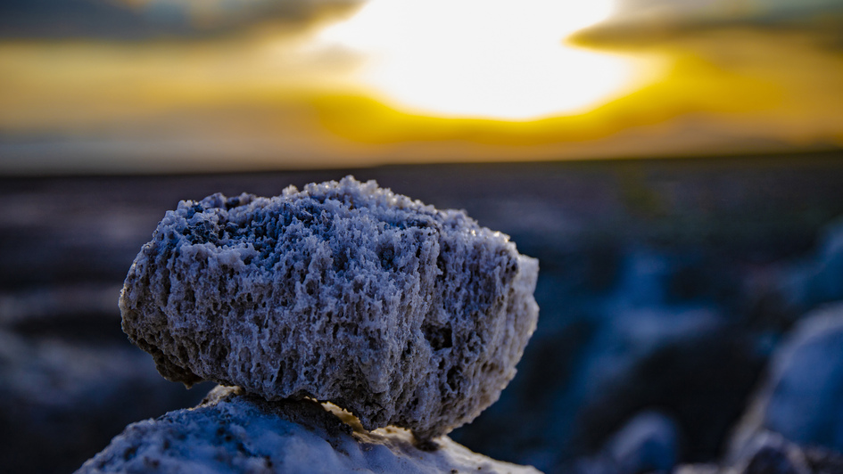 Stein mit Salzablagerungen vor Sonnenuntergang Stein mit Salzablagerungen vor Sonnenuntergang