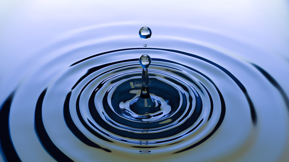 Ein Tropfen fällt ins Wasser und zieht Kreise Ein Tropfen fällt ins Wasser und zieht Kreise