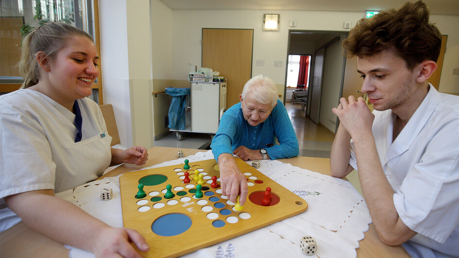 Jugendliche in der Pflegeausbildung mit einer Bewohnerin beim Spiel „Mensch ärgere Dich nicht“ Jugendliche in der Pflegeausbildung mit einer Bewohnerin beim Spiel „Mensch ärgere Dich nicht“