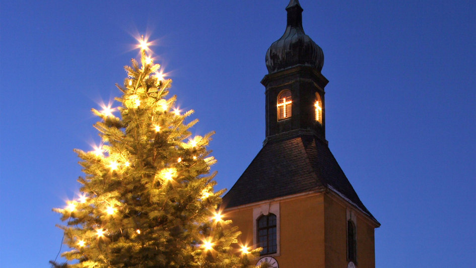 Kirchturm und beleuchteter Weihnachtsbaum