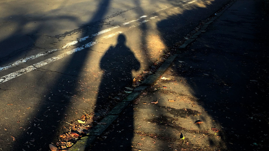 Mensch als Schatten auf einem Weg