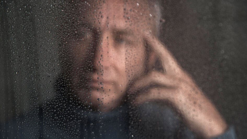 Mann hinter Fensterscheibe mit Tropfen Mann hinter Fensterscheibe mit Tropfen