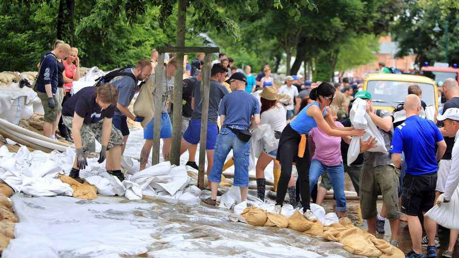 Zivile Helfer bei Hochwasser stapeln Sandsäcke (Archivbild)