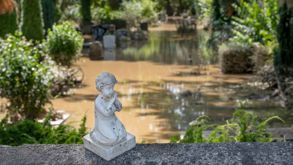 Engelsfigur auf einem überfluteten Friedhof