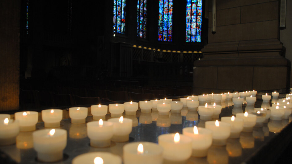 Brennende Kerzen vor Kirchenfenstern Brennende Kerzen vor Kirchenfenstern