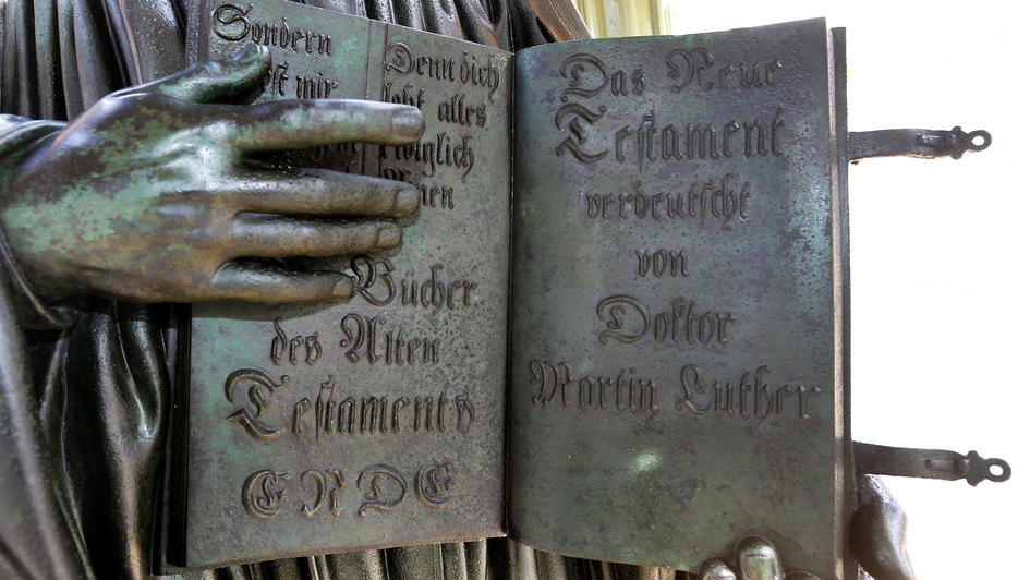 Ausschnitt vom Denkmal des Reformators Martin Luther (1483 - 1546) mit der von ihm ins Deutsche uebersetzten Bibel in der Hand auf dem Marktplatz in Wittenberg