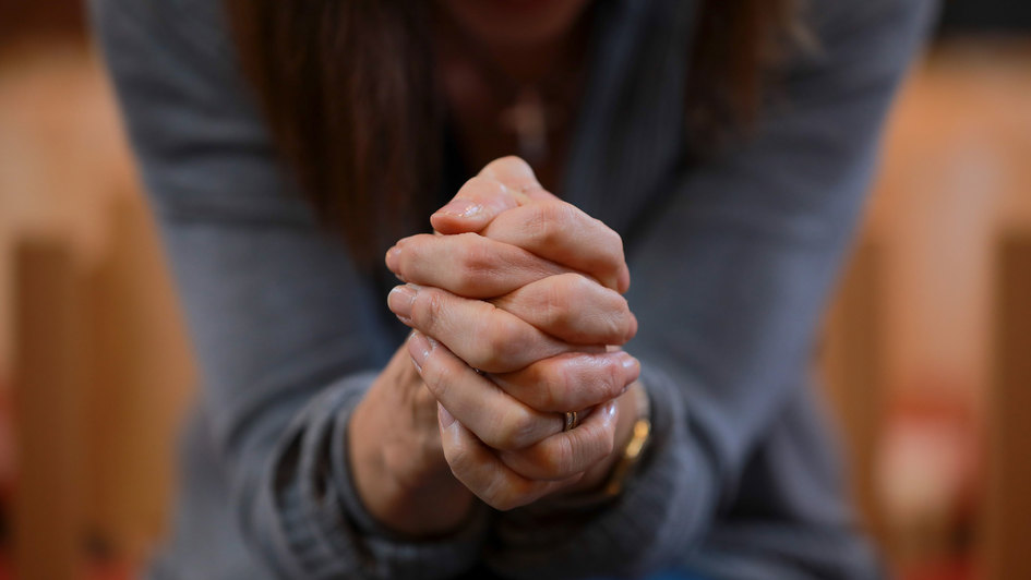 Hände einer Frau zum Gebet gefaltet