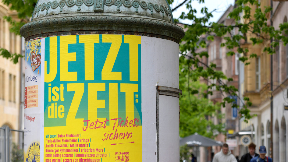 Litfasssäule in der Fußgängerzone in Nürnberg mit Werbeplakat für den Kirchentag