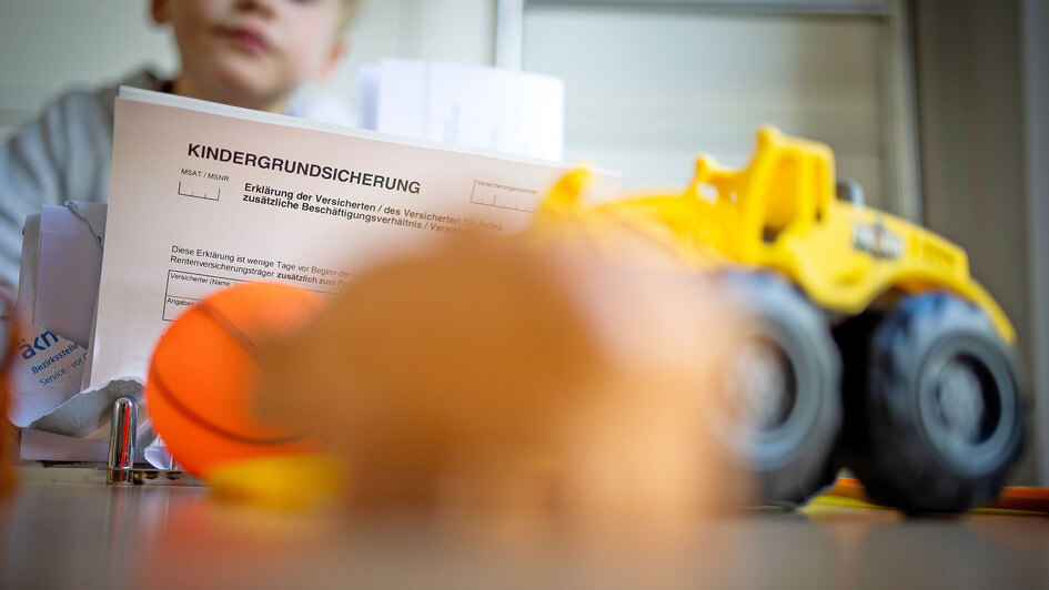 Formular Kindergrundsicherung - im Hintergrund ein Junge ein Kind