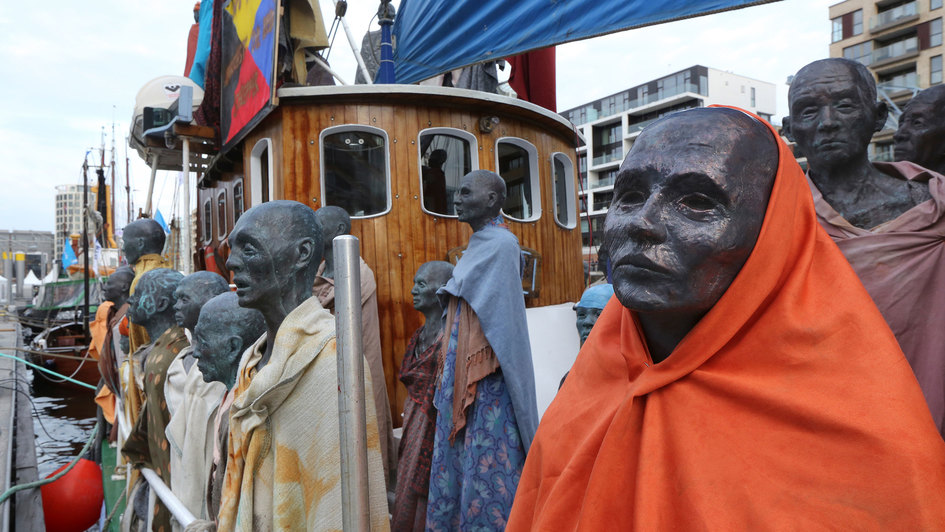 Bronzestatuen von Flüchtlingen auf einem Boot