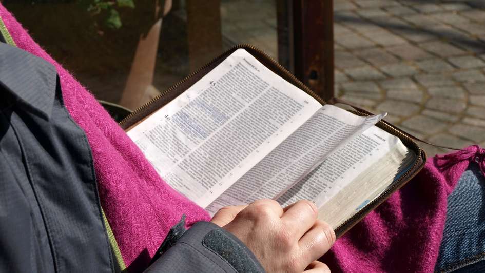 Ein Mensch liest in einer aufgeschlagenen Bibel