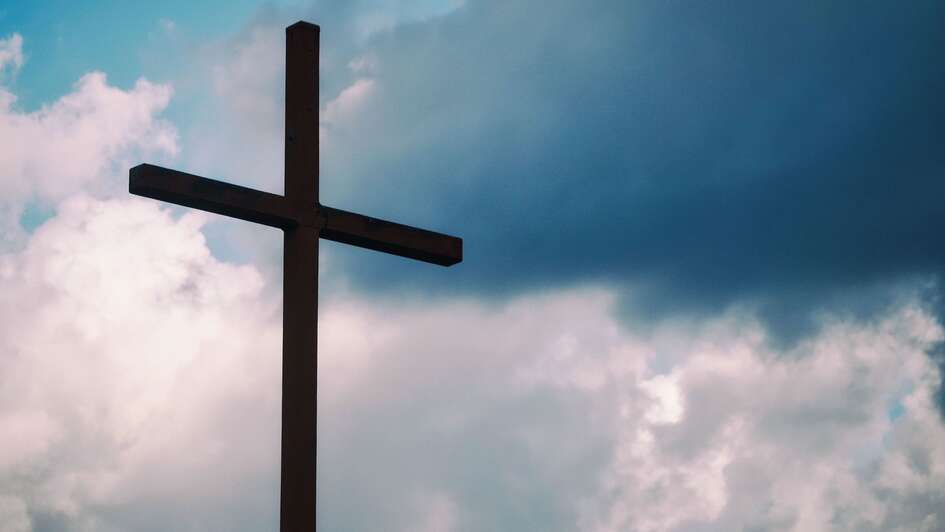 Ein großes hölzernes Kreuz vor Wolkenhimmel Ein großes hölzernes Kreuz vor Wolkenhimmel