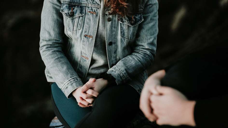 Zwei Menschen im Gespräch mit gefalteten Händen Zwei Menschen im Gespräch mit gefalteten Händen