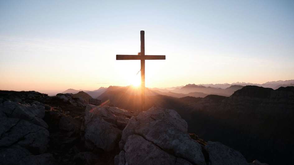 Ein leeres Kreuz vor Sonnenaufgang