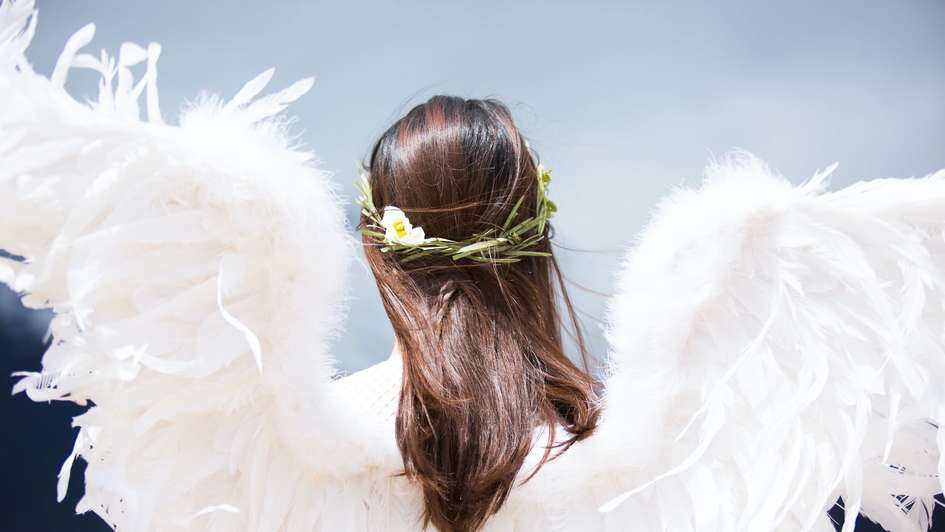 Ein Mädchen mit langen Haaren und Flügeln aus Federn