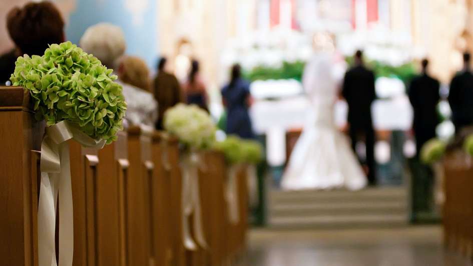 Kirchenbänke mit Blumen geschmückt für eine Hochzeit
