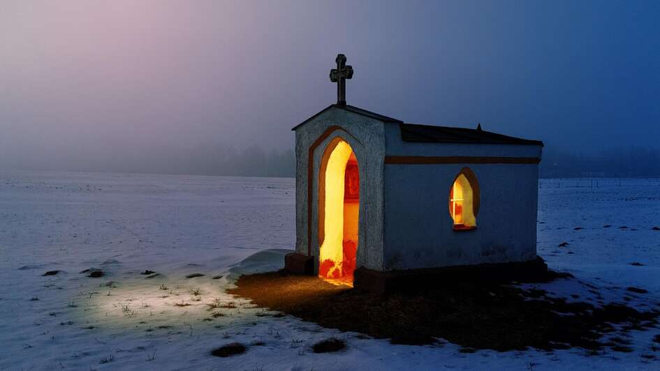 mit kerzen erleuchtete kapelle im winter