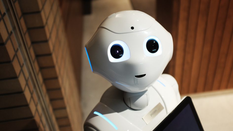 Ein weißer Roboter mit großen Augen (Pepper) schaut in die Kamera.