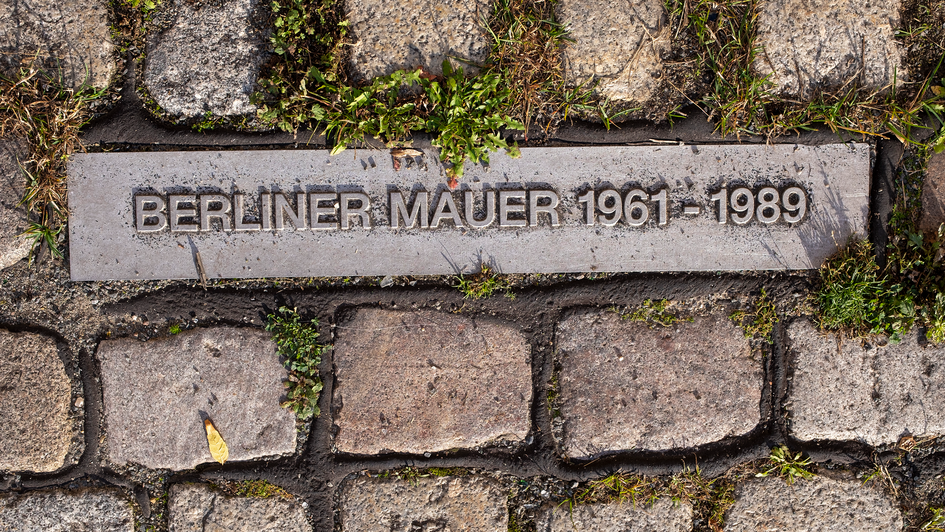 : In den Boden eigelassene Tafeln erinnern an den ehemaligen Verlauf der Berliner Mauer, wie hier am Schiffbauerdamm