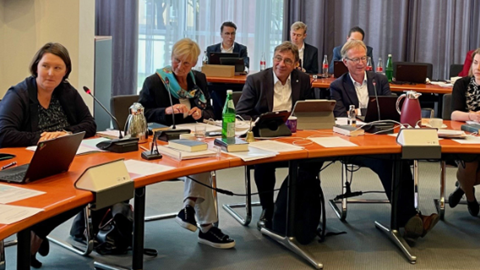 Nicole Toms (ganz links) und Anna-Lena Franke (ganz rechts) erläutern in der Kirchenkonferenz den ForuM-Maßnahmenplan und die Anerkennungsrichtlinie in der Fassung, die das Beteiligungsforum freigegeben hat. Dazwischen die amtierende Ratsvorsitzende Kirst
