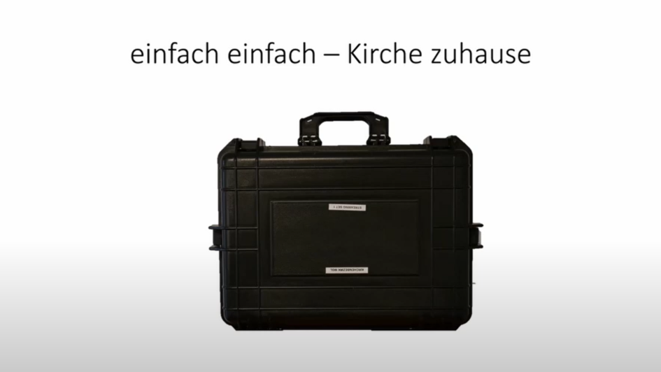 Ein schwarzer Koffer vor weißem Hintergrund. Darüber befinden sich die Worte 'einfach einfach - Kirche zuhause' in schwarzer Schrift. Ein schwarzer Koffer vor weißem Hintergrund. Darüber befinden sich die Worte 'einfach einfach - Kirche zuhause' in schwarzer Schrift.