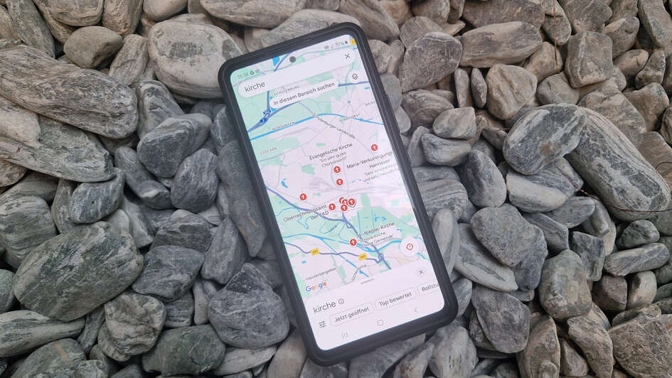 Smartphone auf dem die Standorte von Kirchen auf einer Karte markiert sind Smartphone auf dem die Standorte von Kirchen auf einer Karte markiert sind