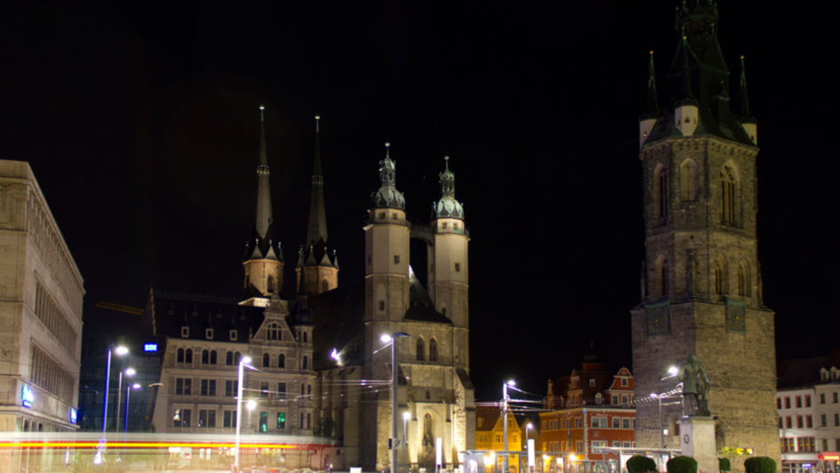 Das Bild zeigt die Marktkirche Unser Lieben Frauen (links) und den Roten Turm bei Nacht. Das Bild wurde in Halle an der Saale aufgenommen