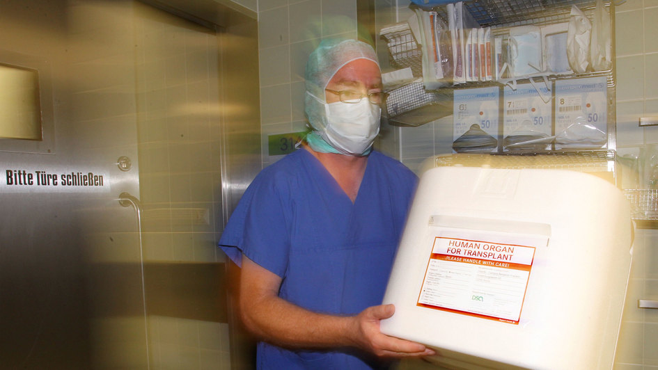 Ein Mitarbeiter des Zentralklinikums Augsburg trägt am 04.07.2011 eine Kühlbox für Spenderorgane durch einen OP-Vorraum.