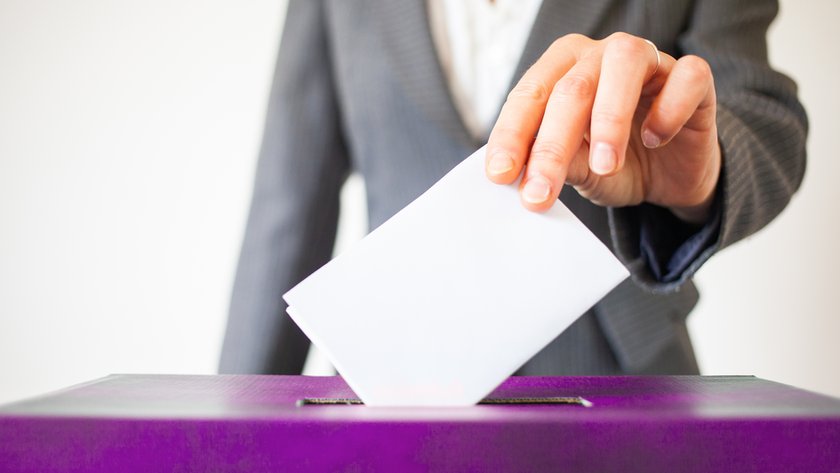 „Symbolbild: Wahlzettel wird in Wahlurne geworfen“
