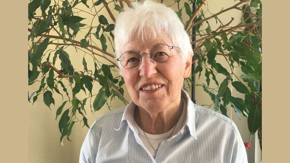 Zu sehen ist die Ehrenamtliche Renate Fiedler-Schöler . Sie trägt weiß-graue, kurze Haare und eine Blicke. Sie blickt freundlich in die Kamera und trägt eine helle gestreifte Bluse.