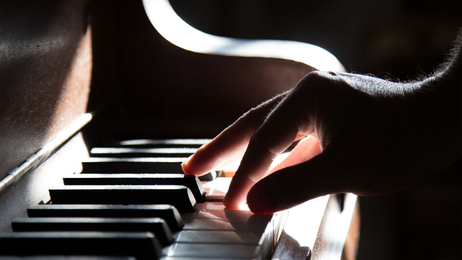 Hand auf einer Klaviertastatur Hand auf einer Klaviertastatur
