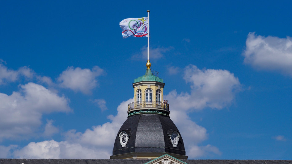 ÖRK Vollversammlung 2022: Fahne am Schloss. Das etwa alle acht Jahre stattfindende Event steht unter dem Motto 'Die Liebe Christi bewegt, versoehnt und eint die Welt'.