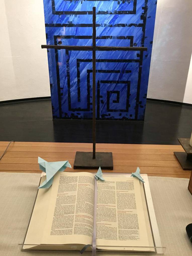 Von der Konfirmand*innengruppe der Evangelischen Kirchengemeinde Dortmund-Berghofen gestaltete Friedenstauben auf der Altarbibel 