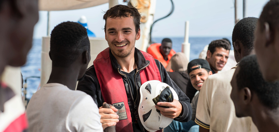 Ein Crew-Mitglied der Sea Watch-2 freut sich mit geretteten Flüchtlingen.