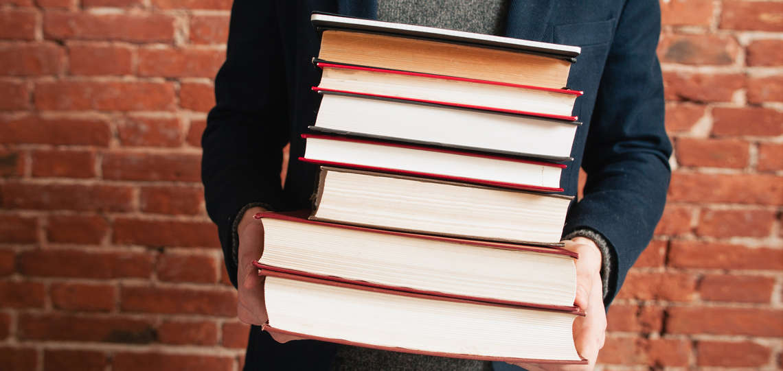 Mann mit einem Stapel Bücher in der Hand. Mann mit einem Stapel Bücher in der Hand.