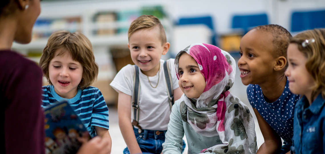 Lehrerin mit multikultureller Gruppe von Kindern. Lehrerin mit multikultureller Gruppe von Kindern.