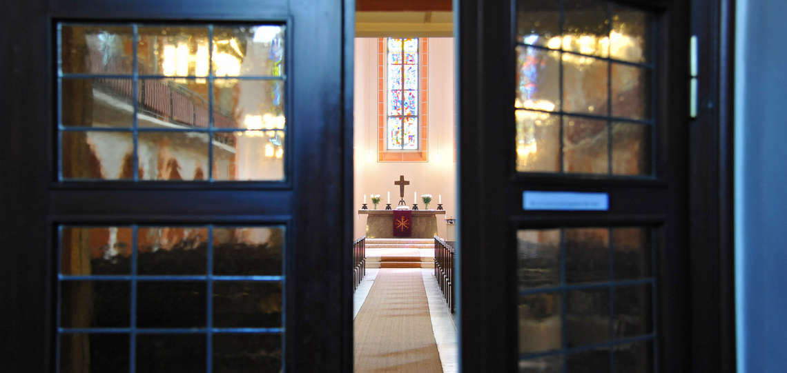 Blick in eine evangelische Kirche durch die geöffnete Tür