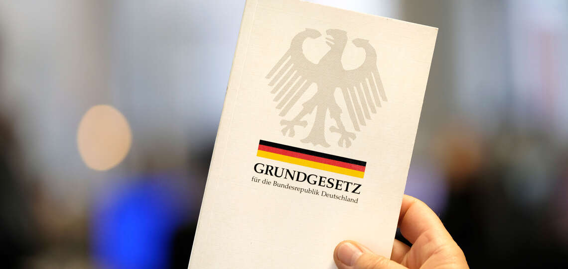 Eine Hand hält das Grundgesetz