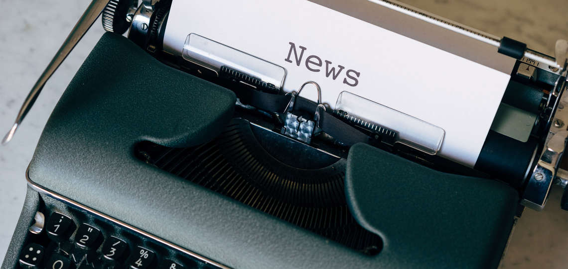 Schreibmaschine mit einem eingespannten Blatt "News"