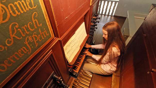 Junge Frau spielt an der Arp-Schnitger-Orgel in der ev. Kirche von Cappel