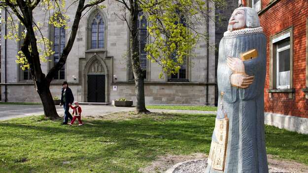 Pfarrer aus Holz vor der Jakobzskirche in Uehlfeld