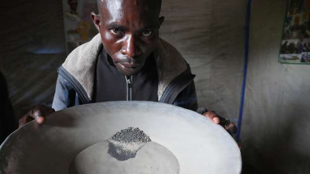Minenarbeiter Audry Bagalwa Bialura zeigt das gemischte Rohmaterial aus Coltan und Kasseterit